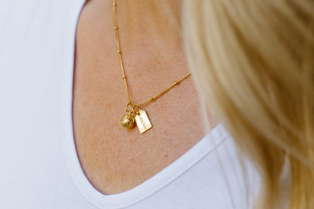 Baseball mom gold charm necklace close up on model