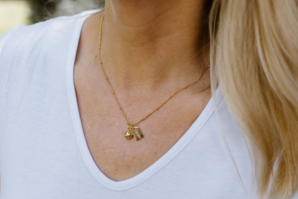 close up of baseball mom gold necklace 