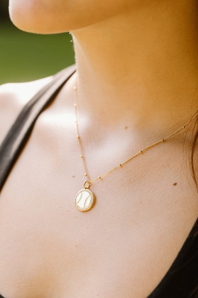 Gold softball necklace with pavé crystals by Chelsea Charles