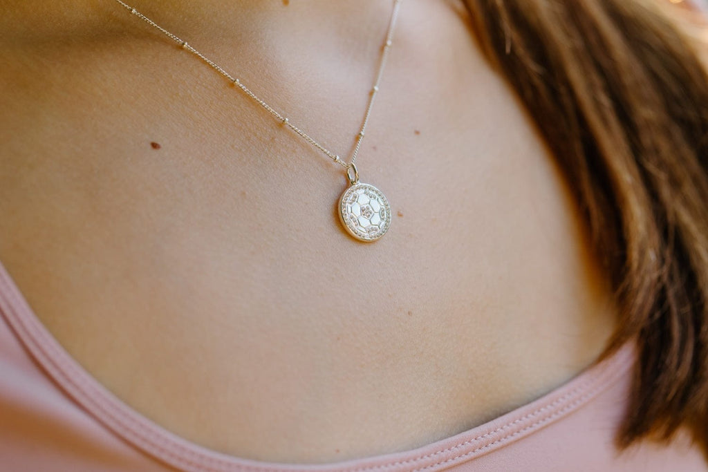 Close up of silver pavé crystal soccer ball necklace by Chelsea Charles