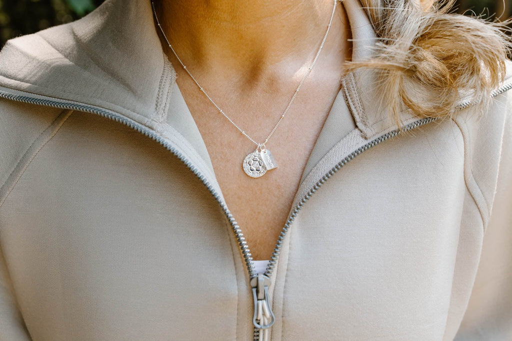 Close up of mom wearing a silver pave soccer mom double charm necklace