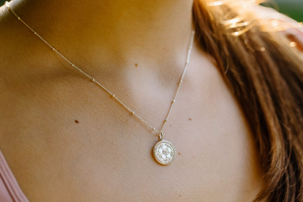 Close up of silver pavé soccer ball necklace by Chelsea Charles