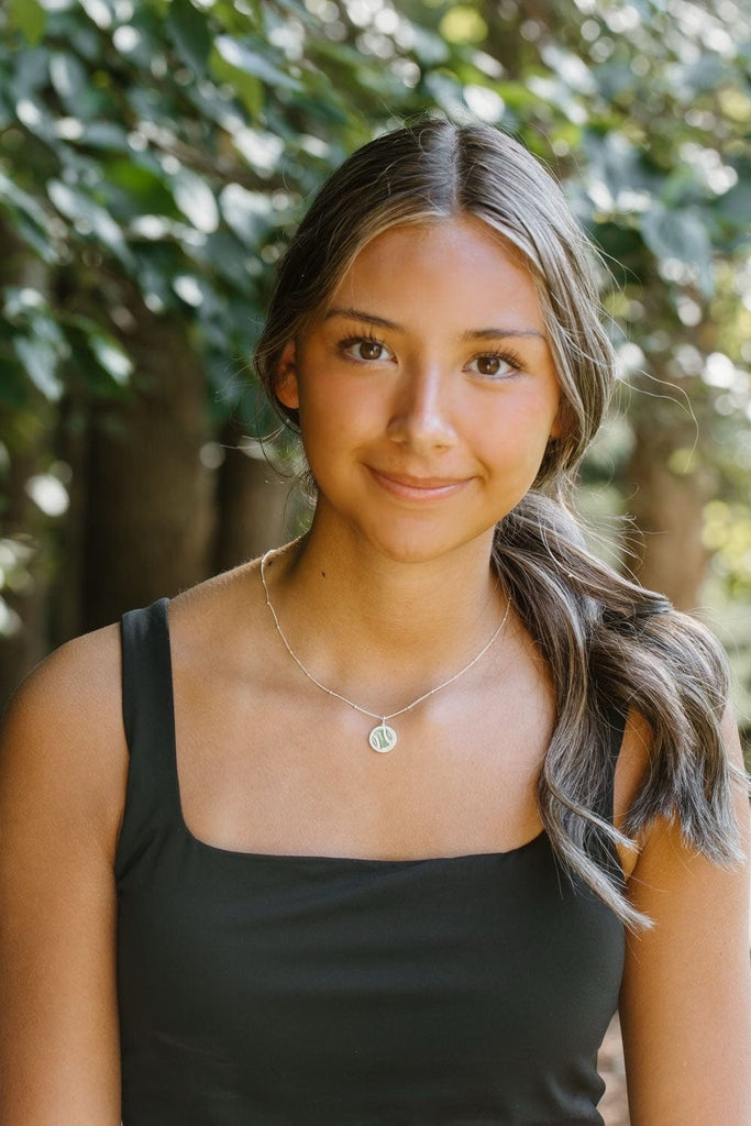 Model wearing softball silver pavé charm necklace by Chelsea Charles