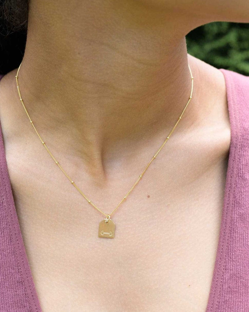 Chelsea Charles reversible gold mini barbell necklace with heart on the back