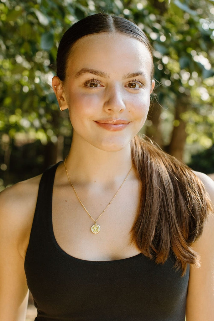 Model wearing gold pavé soccer necklace by Chelsea Charles